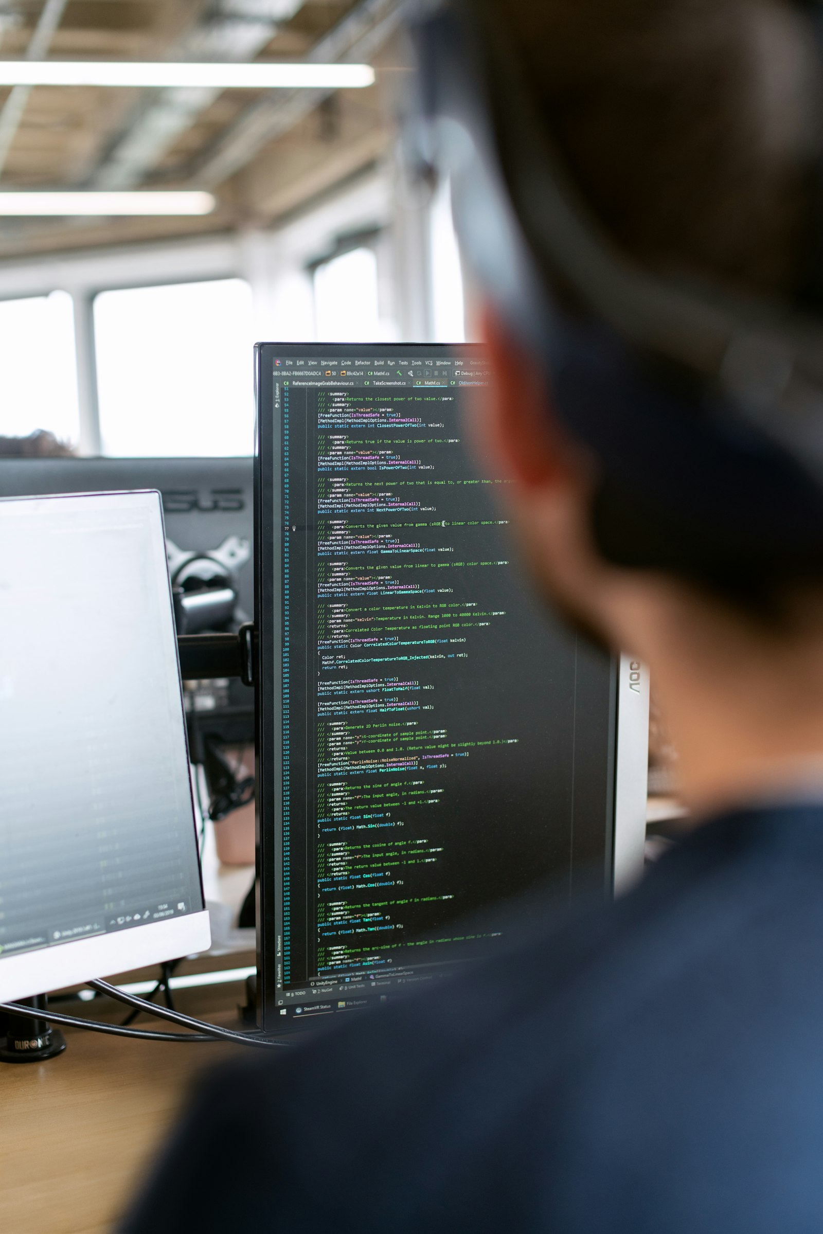 Engineer reviewing project information on multiple screens
